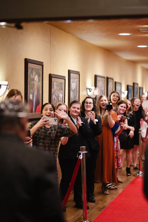 Students cheer for honored guests on the red carpet